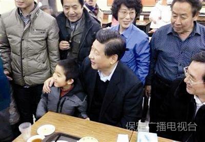 2013年12月28日，习近平在北京市月坛北路庆丰包子铺吃午餐，期间与袁宝小朋友合影。
